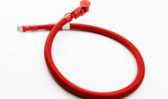 a red hose, possibly a fire hose, lying on a white surface